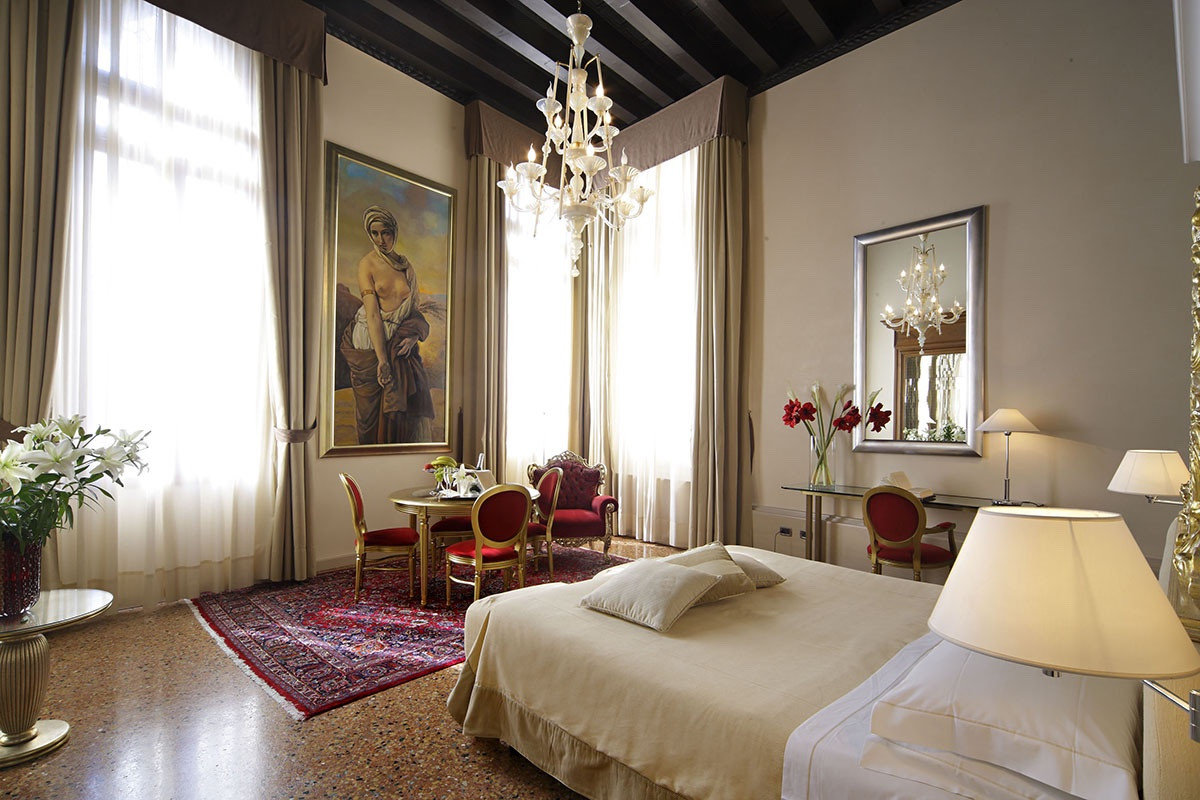 Habitación elegante con toque de terciopelo rojo, una obra de arte colgada y esencia veneciana. 